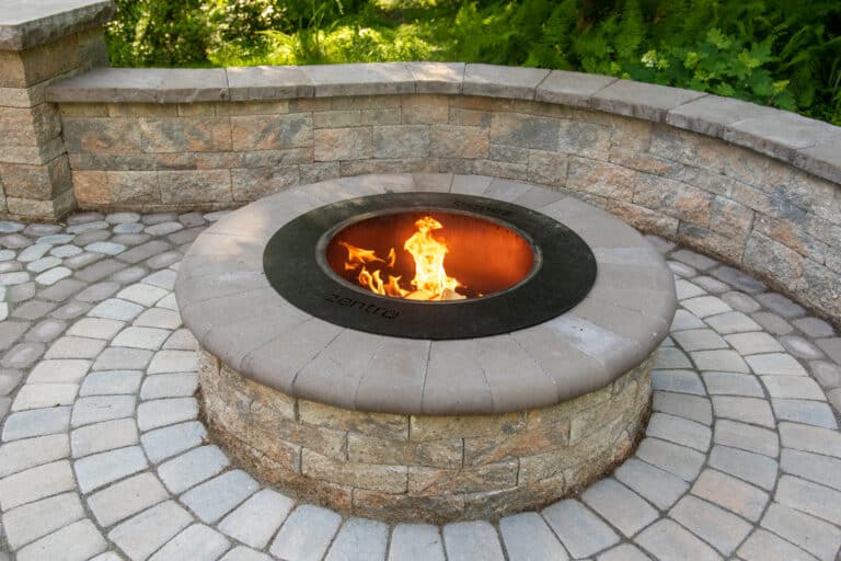 concrete walkway with lit firepit